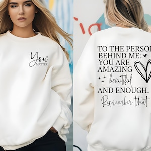 Pu&ograve; includere: Felpa color crema con la scritta "You Matter" sul davanti e "To the person behind me: You are amazing, beautiful, and enough. Remember that" sul retro. Scritta nera.