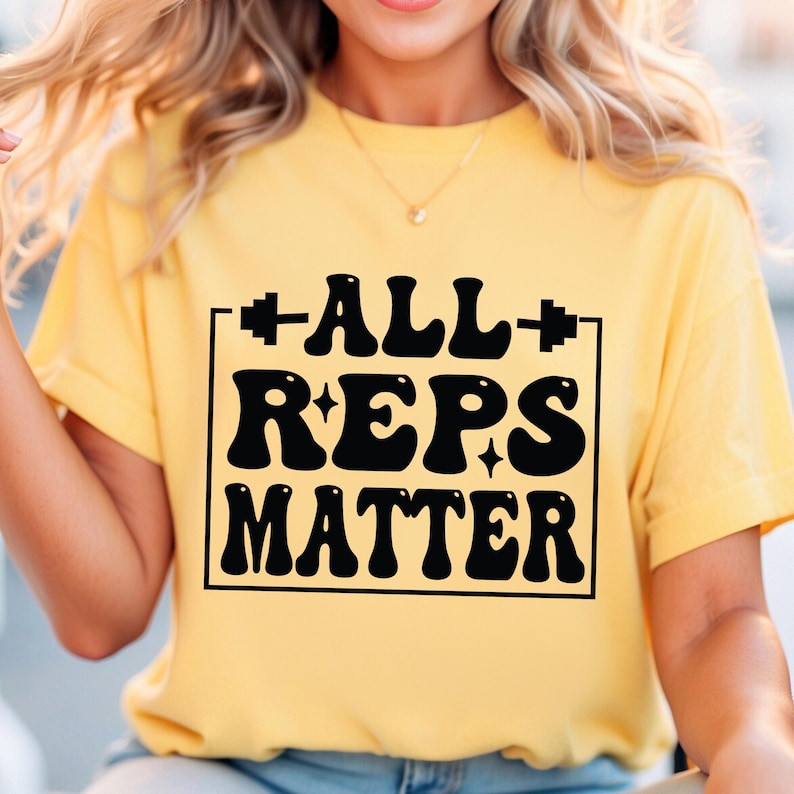 May include: A yellow t-shirt with a black graphic that says "ALL REPS MATTER" in a retro font style. The graphic is surrounded by a black square.