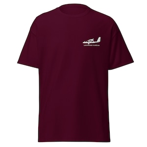 Può includere: T-shirt color borgogna con una silhouette bianca di un piccolo aereo e il testo "Lockwood Aircraft" sul davanti.