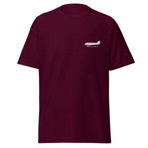 Peut inclure: Un t-shirt bordeaux avec une silhouette blanche d'un avion Douglas DC-3 et le texte "DOUGLAS DC-3" imprimé sur le devant.