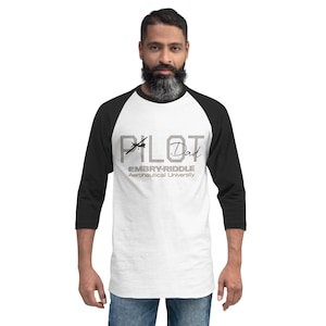 May include: A white and black baseball tee with the text "PILOT Dad" and "EMBRY-RIDDLE Aeronautical University" in gray. The shirt has black sleeves and a white body. The graphic includes an airplane silhouette.