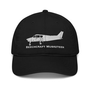 Könnte beinhalten: Schwarze Baseballkappe mit einem weißen gestickten Bild eines Beechcraft Musketeer Flugzeugs und dem Text "BEECHCRAFT MUSKETEER".