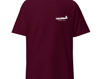 May include: A maroon t-shirt with a white silhouette of a Mooney M20 aircraft on the left chest.