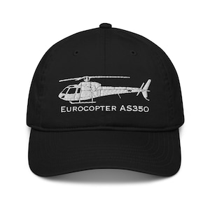 Op de afbeelding: Zwarte baseballpet met een wit geborduurd beeld van een helikopter en de tekst "EUROCOPTER AS350".