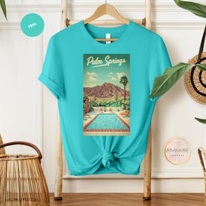 Peut inclure: T-shirt bleu turquoise avec un motif vintage d'une piscine et de palmiers &agrave; Palm Springs, Californie.
