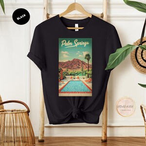 Peut inclure: T-shirt noir avec un graphique vintage d'une piscine et de palmiers &agrave; Palm Springs, Californie. Le texte "Palm Springs, Californie" est imprim&eacute; sur le graphique.