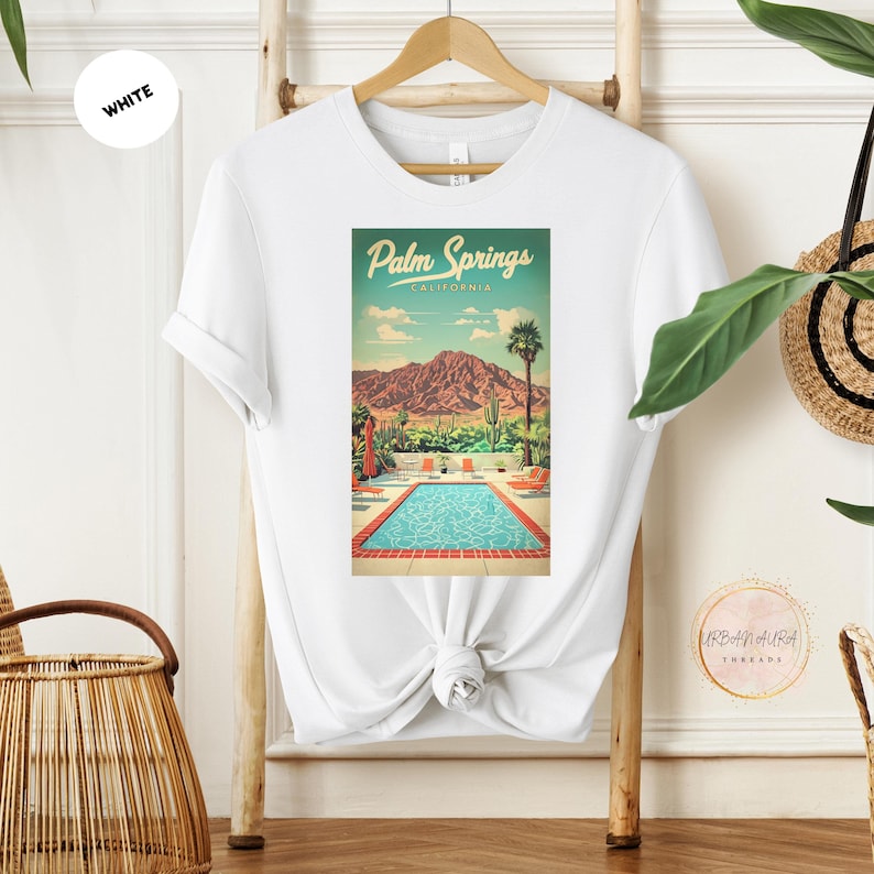 Peut inclure: T-shirt blanc avec un imprim&eacute; graphique d'une illustration r&eacute;tro d'une piscine et de palmiers avec le texte "Palm Springs, Californie".