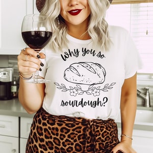 Peut inclure: T-shirt blanc avec un graphique noir d'une miche de pain au levain et le texte "Why you so sourdough?"
