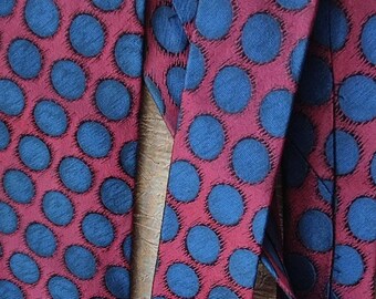 May include: Two red ties with a blue polka dot pattern. The ties are made of a silky material.