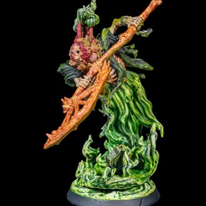 May include: A green and orange skeletal figure with a large, gnarled, orange weapon. The figure is standing on a green and black base.