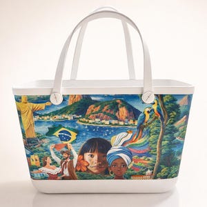 May include: White tote bag with a colorful illustration of Brazilian landmarks, people, and the Brazilian flag. The bag features a white handle and a white base. The illustration includes the Christ the Redeemer statue, mountains, and parrots.