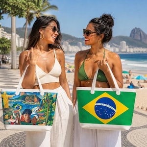 May include: Two women on a sunny beach holding tote bags. One bag features a colorful Brazilian landscape scene, the other displays the Brazilian flag. Both bags have white handles and trim. The women are wearing sunglasses and smiling.