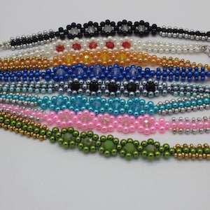Op de afbeelding: Een set van acht kralenarmbanden met magneetsluitingen. De armbanden zijn gemaakt met verschillende kleuren kralen, waaronder zwart, wit, rood, oranje, blauw, turquoise, roze en groen.