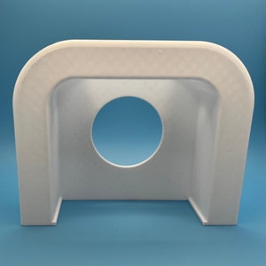 May include: White plastic cover with a round opening in the center. The cover is designed to fit over a circular object.