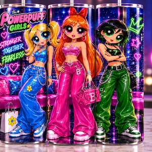 Puede incluir: Un vaso cilíndrico con los personajes de Las Chicas Superpoderosas en atuendos vibrantes. El diseño incluye el texto "STRONGER TOGETHER FEARLESS" sobre un fondo de luces de neón con corazones, estrellas y una corona. Los personajes visten ropa azul, rosa y verde.