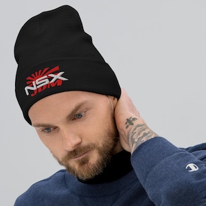 May include: Black beanie with the text "NSX JDM" in white and red embroidery. The design includes a rising sun graphic. The beanie is made of a soft material.