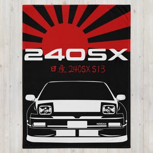 May include: A black and white illustration of a Nissan 240SX S13 car with a red and white rising sun graphic in the background. The text "240SX" and "日産 240SX S13" is printed in white on the black background.