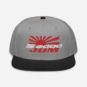 May include: A gray and black baseball cap with a red and white embroidered Japanese rising sun and the text "S2000 JDM".