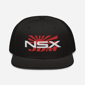 Puede incluir: Gorra de béisbol negra con una bandera japonesa bordada en rojo y blanco y el texto "NSX JDM".