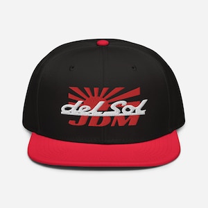 May include: Black and red baseball cap with a white embroidered logo that says "del Sol JDM" and a red rising sun graphic.