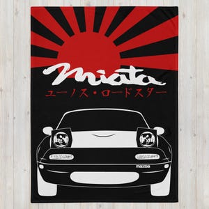May include: A black and white illustration of a Mazda Miata with the text "Miata" and "ユーノス・ロードスター" on a red and black Japanese rising sun background.