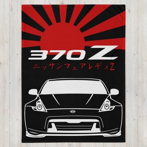 May include: Black and white illustration of a Nissan 370Z with a red and black Japanese rising sun design behind it. The text "370Z" and "Nissan Fairlady" is written in white on a black background.