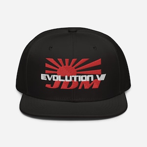 May include: Black baseball cap with a red and white Japanese rising sun graphic and the text "Evolution VII JDM" embroidered on the front.