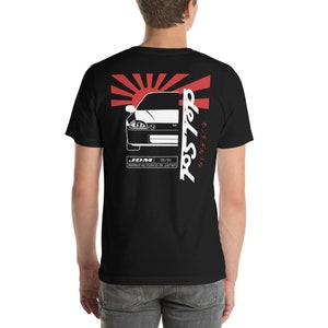 May include: Black t-shirt featuring a white graphic of a car, a rising sun, and the text "del Sol" in Japanese and English. The text "JDM 92-95 MANUFACTURED IN JAPAN" is also included.