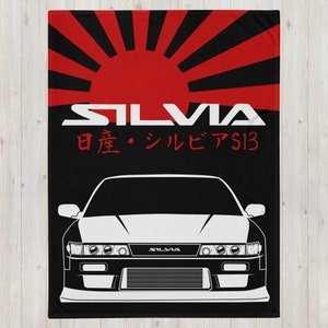 May include: A black and white illustration of a Nissan Silvia S13 with a red and black Japanese rising sun background. The text "SILVIA" and "日産・シルビアS13" is printed in white.