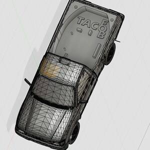 Könnte beinhalten: Ein schwarzer und grauer Pickup mit einem weißen "TACO"-Logo auf der Ladefläche. Der LKW ist ein 3D-Modell und in einem Drahtgitter-Stil gerendert.