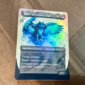 May include: A holographic trading card featuring a blue owl with outstretched wings, titled "Maha, Its Feathers Night." The card is labeled "Legendary Creature - Elemental Bird" and includes game text. The card has a 6/5 power and toughness.