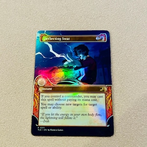 May include: A holographic trading card titled "Deflecting Swat" with a fantasy illustration of a figure deflecting energy. The card features text including a quote by Iroh and the word "Instant".