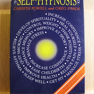May include: A navy blue box set titled "The Self-Hypnosis Kit" by Cherith Rowell and Greg Forde. The cover features a yellow circle and white text listing benefits like managing stress and improving sleep. Includes a 60-minute audio tape.