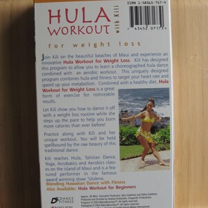 Peut inclure: Un bo&icirc;tier de DVD bleu et blanc avec une photo d'une femme en haut jaune et jupe florale dansant sur une plage. Le bo&icirc;tier est pour un Hula Workout for Weight Loss avec Kili. Le texte sur le bo&icirc;tier indique "Naturaljourneys" et "Hula Workout for Weight Loss".