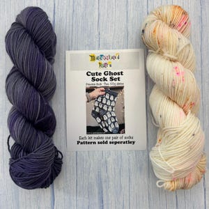 Può includere: Due matasse di filato da 50g e una scheda prodotto. Una matassa è viola scuro tinta unita, l'altra è color crema con macchie rosa e arancioni. La scheda riporta Magicaland Yarn, Cute Ghost Sock Set, Princess Sock e che il modello è venduto a parte.