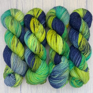 May include: A set of three ceramic nesting bowls in shades of blue, green, and white. The bowls have a speckled glaze and a simple, modern design. The largest bowl is approximately 15 cm in diameter.