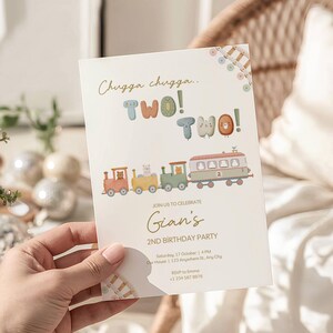 May include: A cream-colored birthday party invitation with a train theme. The text reads "Chugga chugga.. TWO! TWO!" and "Gian's 2nd Birthday Party." The invitation includes a train illustration with animal characters.