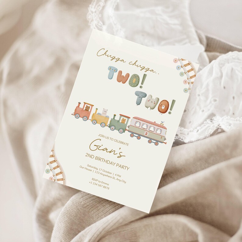 May include: A cream-colored birthday party invitation with a train illustration. The text reads "Chugga chugga... TWO! TWO!" and "Gian's 2nd Birthday Party." The train cars are in pastel colors, and the invitation includes date, time, and RSVP information.