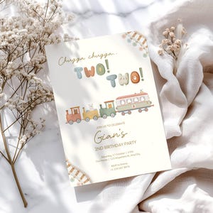 May include: A cream-colored birthday party invitation with a train illustration. The text reads "Chugga chugga.. TWO! TWO!" and "Gian's 2nd Birthday Party". The train cars are in shades of red, yellow, green, and white.
