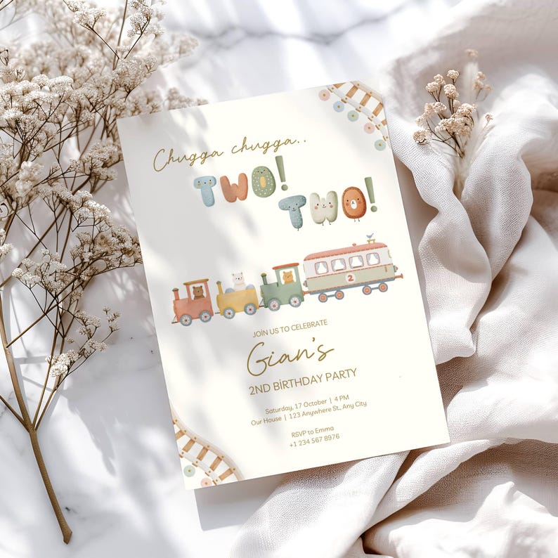 May include: A cream-colored birthday party invitation with a train illustration. The text reads "Chugga chugga.. TWO! TWO!" and "Gian's 2nd Birthday Party". The train cars are in shades of red, yellow, green, and white.