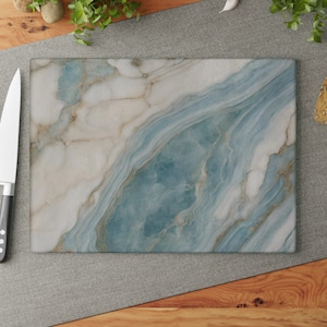 May include: A blue and white marble cutting board with a swirling pattern. The board is made of tempered glass and is heat resistant.