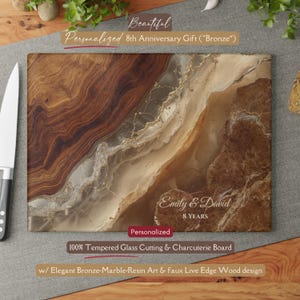 Peut inclure: Planche à découper rectangulaire avec un motif en résine bronze-marbre et un bord en faux bois. La planche est personnalisée avec les noms "Emily & David" et le texte "8 YEARS". Le texte "100% Tempered Glass Cutting & Charcuterie Board" est également visible.