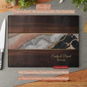 May include: A rectangular tempered glass cutting board featuring a dark walnut wood grain pattern on the top and bottom sections, separated by a central band of coral, white, and black marble with gold veining. The text Emily & David 35 Years is printed in gold.