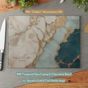May include: A rectangular tempered glass cutting and charcuterie board with a gold and teal marble design. The text "50th Golden Anniversary Gift" and "Happily Ever After 50 Years" are printed on the board. The text "100% Tempered Glass Cutting & Charcuterie Board" is also printed on the board.