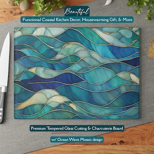 May include: A rectangular tempered glass cutting board with an ocean wave mosaic design in shades of blue and teal, accented with gold lines. The text "Beautiful" and "Functional Coastal Kitchen Decor, Housewarming Gift, & More" are at the top. The text "Premium Tempered Glass Cutting & Charcuterie Board w/ Ocean Wave Mosaic design" is at the bottom.
