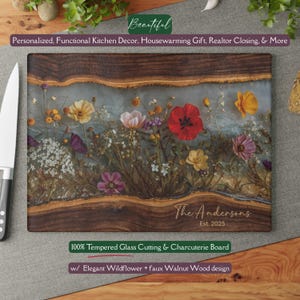 May include: A rectangular cutting board with a faux walnut wood design and a clear resin center filled with colorful wildflowers. The board has the text "The Andersons Est. 2025" and "100% Tempered Glass Cutting & Charcuterie Board".