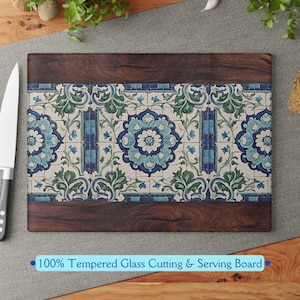 May include: A rectangular tempered glass cutting and serving board with a wood frame. The board features a blue and green floral tile pattern.