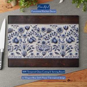 May include: Rectangular cutting board with a dark wood border and a central panel featuring a blue and white floral design. The text "Beautiful Functional Kitchen Decor" and "100% Tempered Glass Cutting & Serving Board w/ Elegant Blue Delft Floral Tile-inspired design" are visible.