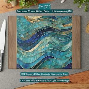 May include: A rectangular tempered glass cutting and charcuterie board featuring a central panel with a blue, teal, and gold ocean wave mosaic pattern, flanked by two vertical panels with a light wood grain design on the left and right sides.