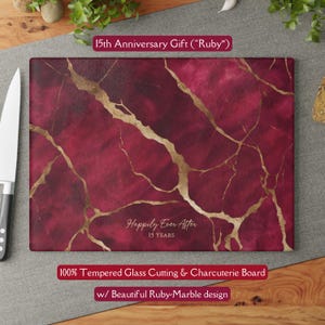 May include: A rectangular tempered glass cutting board with a ruby-marble design and gold veining. The text "Happily Ever After 15 YEARS" is displayed. The text "15th Anniversary Gift (Ruby)" and "100% Tempered Glass Cutting & Charcuterie Board w/ Beautiful Ruby-Marble design" are also visible.
